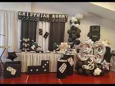 a party with black and white decorations and balloons