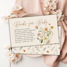 a card that reads books for baby next to some flowers on a plate and cloth