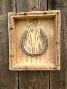 a wooden frame with a metal horseshoe on it