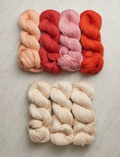 four skeins of yarn laid out on a marble surface