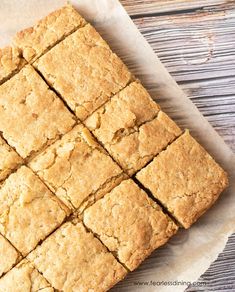 a close up of squares of food on a piece of paper next to a wooden table