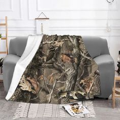 a couch with a blanket on top of it in front of a white wall and floor