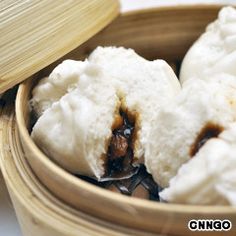 steamed dumplings in a wooden bowl with chopsticks