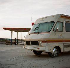 an rv parked in front of a gas station with no one around it or on the ground