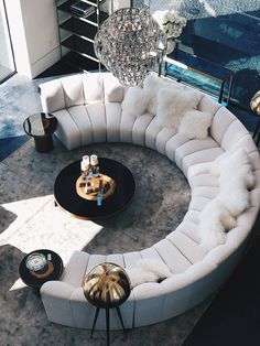 a living room with white couches and a chandelier hanging from the ceiling