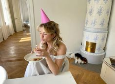 a woman in a party hat eating cake