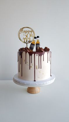 a birthday cake with two bottles of booze on top and chocolate drizzle