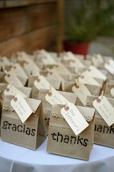 small brown bags with tags on them sitting on top of a white table covered in paper