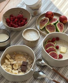 bowls of oatmeal, fruit and milk on a table