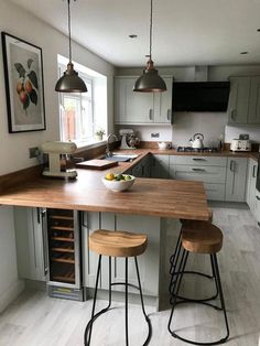 a kitchen island with two stools in front of it