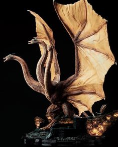 a statue of a dragon with its wings spread out and eyes wide open, on a black background