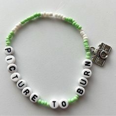 a green and white beaded bracelet with words written in small letters on the beads