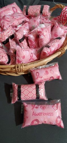 a basket filled with lots of pink candies next to some candy bars on top of a table