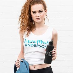 a young woman is holding a water bottle