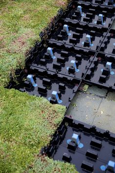 several black plastic containers sitting on top of green grass