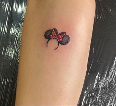 a tattoo on the arm of a woman with a red and black minnie mouse head