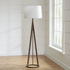 a wooden floor lamp with a white shade