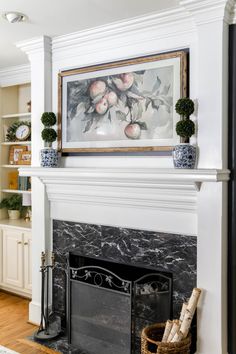 a white fireplace with a painting above it