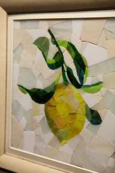 an art piece made out of pieces of paper with a yellow and green apple on it