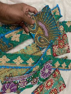 a person is working on an embroidered piece with beads and sequins in it