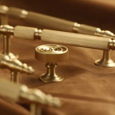 two brass knobs on the side of a brown cloth with other metal knobs