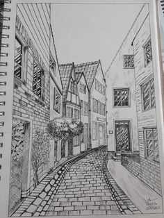 a pencil drawing of some buildings on a street with cobblestone roads and trees