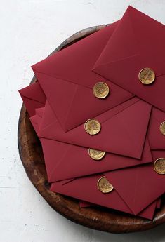 a wooden bowl filled with lots of red envelopes