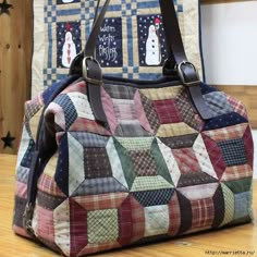 a quilted handbag sitting on top of a wooden table next to a wall