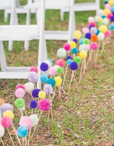 a bunch of colorful pom poms sitting in the grass