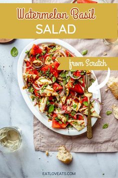 a white plate topped with salad next to bread