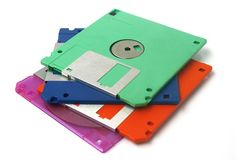 a pile of floppy disk disks stacked on top of each other in different colors and sizes