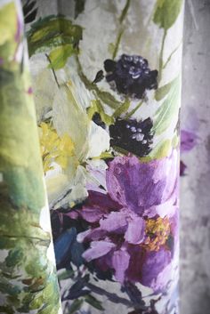 three different colored curtains with flowers painted on them, one is green and the other is purple