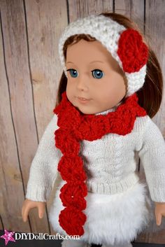 the doll is wearing a white sweater and red scarf with a knitted hat on her head