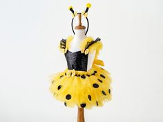 a mannequin dressed in yellow and black polka dot tutu with headband