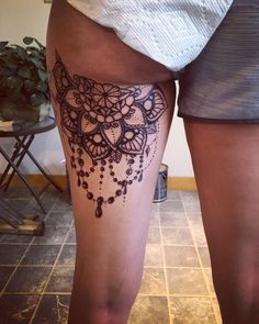 a woman's leg with a tattoo on it that has an intricate design and beads