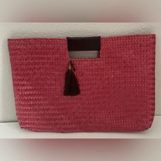 a red bag with a tassel hanging from it's front pocket on a shelf