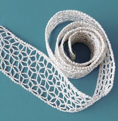 a roll of white lace sitting on top of a blue surface