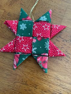 an ornament made out of red and green fabric with white stars on it