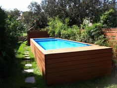 an above ground swimming pool surrounded by greenery