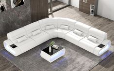 a white leather sectional sofa sitting on top of a rug