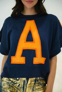 Take your gameday look to the next level with this GAMEDAY LETTER PATCH TOP! Crafted from a comfy navy material and featuring an oversized orange letter patch and orange stitch detailing, this is the perfect way to cheer on your team in style. Go team! Navy Top With Embroidered Logo For College, Navy Tops For Game Day During Sports Season, Blue Varsity Tops For Game Day, Collegiate Navy Top For Game Day, Navy Collegiate Top For Streetwear, Navy Collegiate Top For College, Navy Collegiate Style Top, Navy Team Spirit Top For Streetwear, Game Day Tops With Embroidered Logo