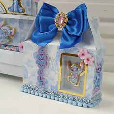 a small box with a blue bow on the top and an image of a mouse inside