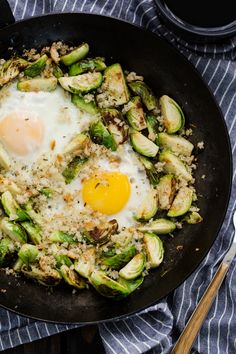 an egg is in a skillet with brussel sprouts on the side