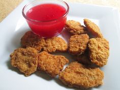 chicken nuggets with ketchup on a white plate