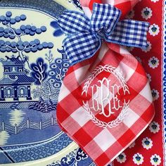 the monogrammed napkins are tied on top of blue and white china plates