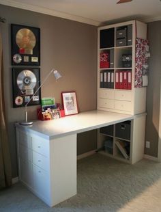 a white desk sitting under a window next to a wall mounted cd player and record player