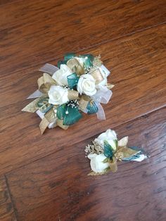 two small white flowers sitting on top of a wooden table