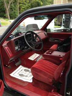 the interior of a red car with its door open