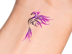 a bird tattoo on the back of a woman's left arm, with pink ink