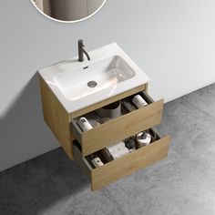 a bathroom sink sitting under a mirror on top of a wooden cabinet next to a counter